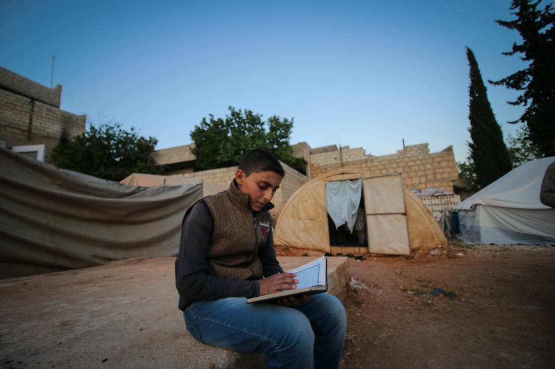 A child studying in a refugee camp