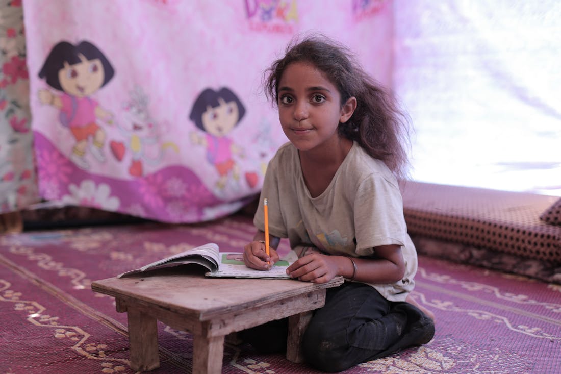 A girl studying in a tent
